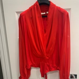 Eva Mendes Reddish orange body suit.